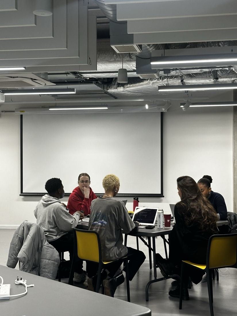 Small groups of students working together around tables.