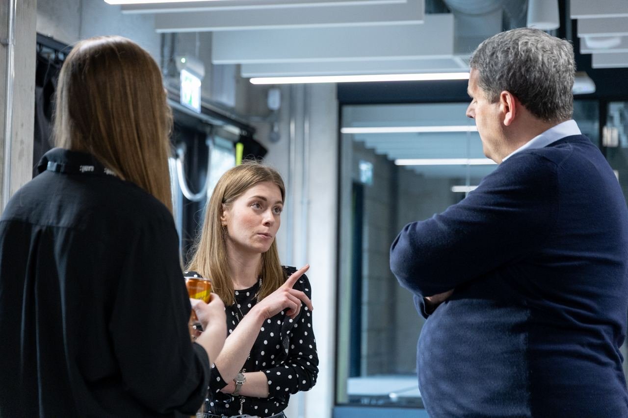 Students and guests deep in conversation after a talk.