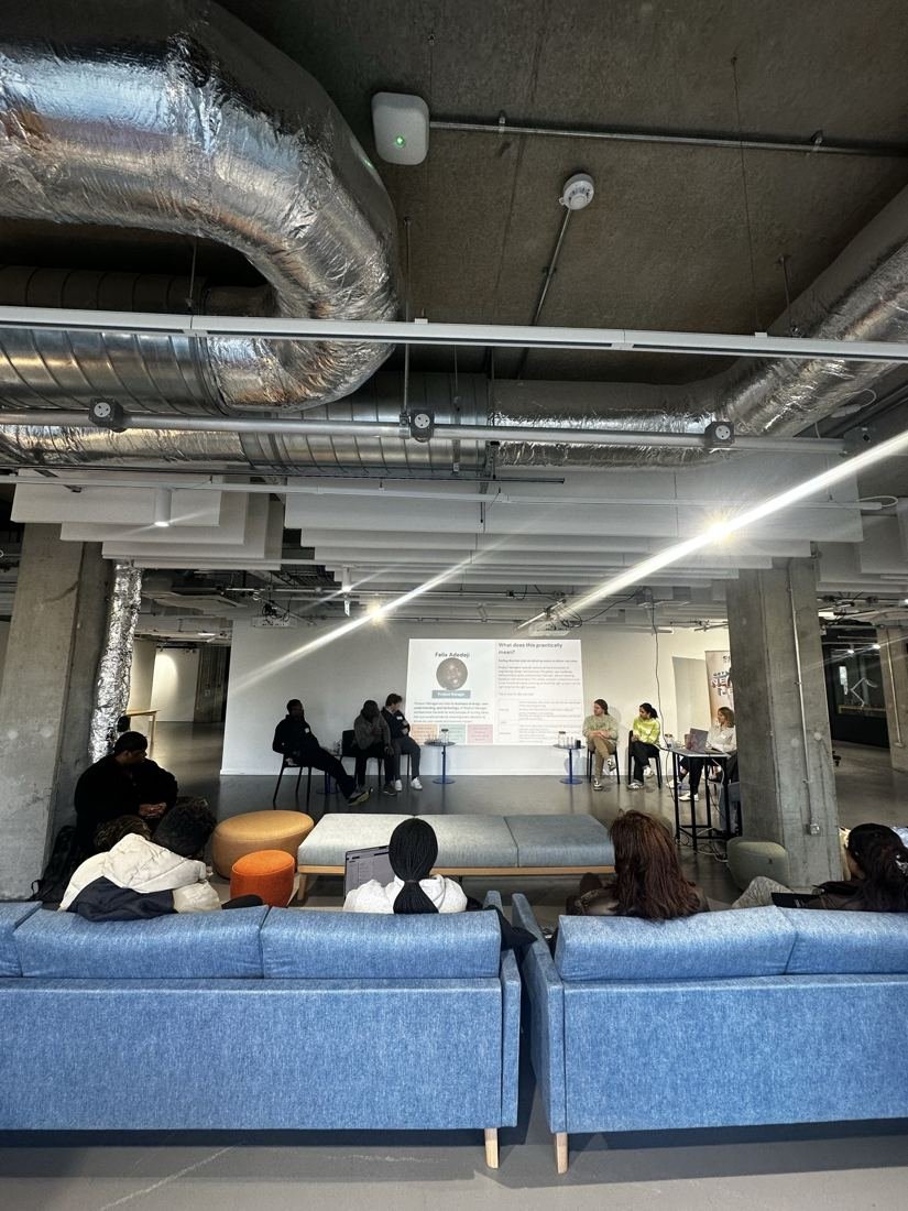 Students on sofas listening to a talk in a large open seminar space.